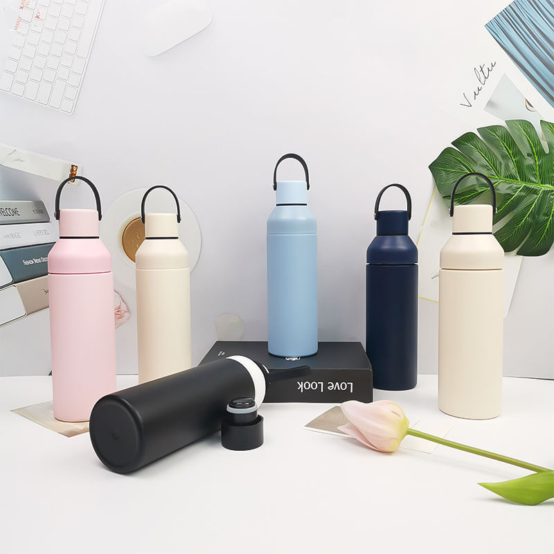 Convertible insulated bottles in multiple colors on desktop scene